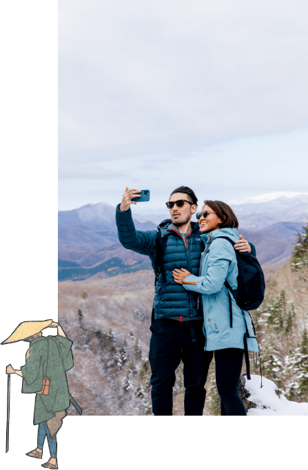 写真：山頂で自撮りをしている男女と、それを眺めている旅人の浮世絵